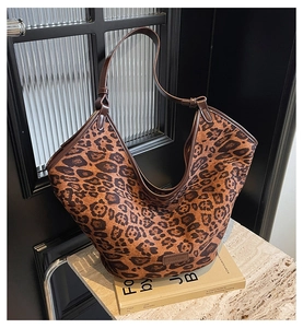 Detailed view of brown leopard print tote bag placed on a decorative book background