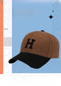 Detailed close-up showing the precision stitching on the brown and black wool baseball cap