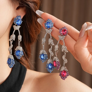 Detail of vintage flower tassel earrings with blue and pink gemstones on silver base