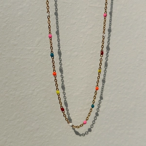 Detail of 18k gold plated necklace featuring colorful resin beads on a fine link chain