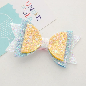 Close-up of a multi-layer sequin bow hair clip with lemon slice motif for girls