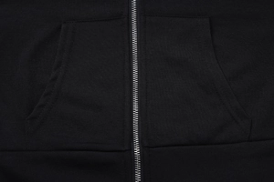 Primer plano de la cremallera metálica y la textura de una chaqueta negra con capucha
