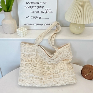 Detailed close-up of beige lace tote bag with tiered ruffles and woven cotton texture