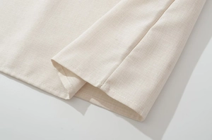Makroaufnahme der naturweißen Leinentextur und feinen Nähte am Spitzenkleid