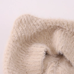 Gros plan sur la maille beige douce et la texture pelucheuse du béret pour enfants