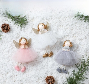 Close-up of pearl crown angel ornaments with glitter wings on snowy background