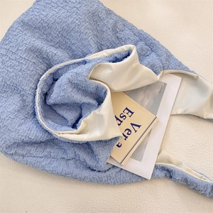 Detail shot of light blue bubble texture fabric and ivory lining of the large tote bag