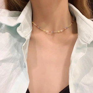 Close-up of a model wearing the colorful square crystal beaded necklace with gold accents