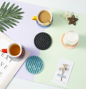 Flat lay of colorful 10cm round silicone coasters with geometric anti-slip textures