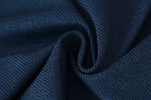 Vue détaillée du tissu sergé bleu marine de haute qualité montrant une texture côtelée