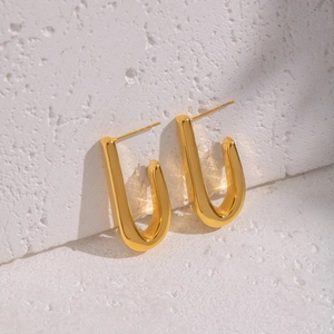 Minimalist 18K gold plated stainless steel hook earrings on white textured stone background