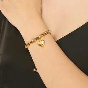 Close-up of 18K gold plated bead bracelet with hollow heart pendant on wrist