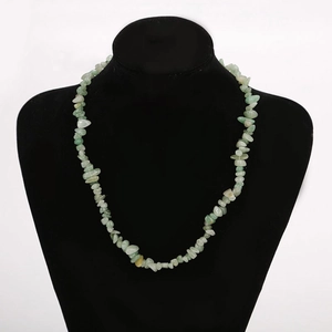 Detailed view of light green natural crystal stone beads on a black necklace display