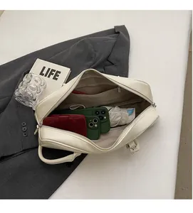 Interior view showing large capacity for phones, wallet, and umbrella in cream baguette bag