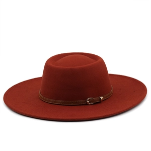 Close-up of wool fedora with brown leather strap and metal buckle on wide brim