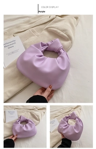 Detail of purple pleated cloud bag featuring a knotted handle and leather texture