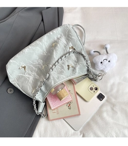 Detail view of silver butterfly shoulder bag showing spacious interior with essentials