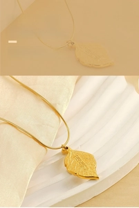 Close-up of golden leaf pendant with fine vein textures and chinese character on snake chain