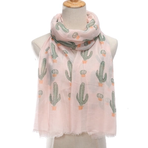 Light pink women's scarf with green cactus print and tassels on a white background