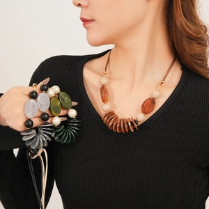 Detail of vintage layered oval pendant necklaces in amber brown and grey black resin beads