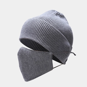 Detailed close-up of dark grey knitted beanie and matching face mask set for winter