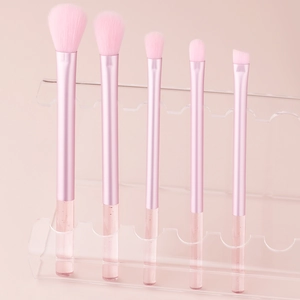 5-piece pink makeup brush set with crystal handles on a transparent display stand