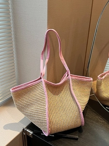 Large beige woven straw tote bag with pink fabric trim and handles for summer