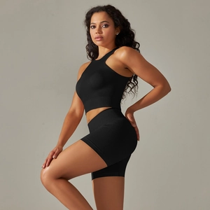 Side view of seamless black knit yoga set showing crop top and high waist shorts