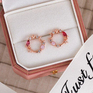 Macro shot of rose gold flower earrings with pink zircons in a pink velvet jewelry box