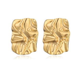 Macro view of 18K gold plated earrings with irregular geometric texture on white background