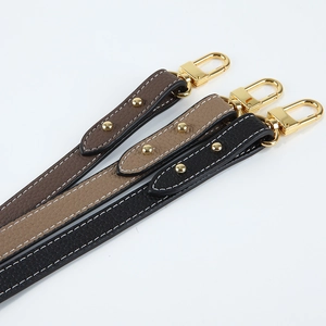 Close-up of adjustable lychee pattern leather shoulder straps with gold metal hooks