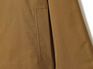 Macro shot of brown twill woven fabric details and premium stitching on short trench coat