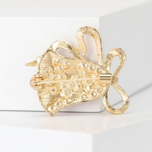Back view of gold Christmas bell brooch showing secure metal safety pin and texture