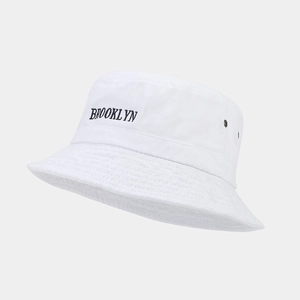 Détail d'un bob en coton blanc avec broderie Brooklyn noire et œillets d'aération