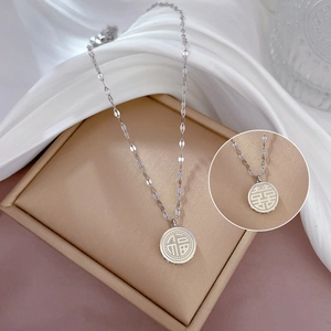 Dettaglio macro della collana in acciaio titanio con pendente doppia faccia Fu e Xi