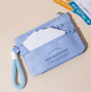 Close-up of light blue travel passport organizer with triple zippers and hand strap