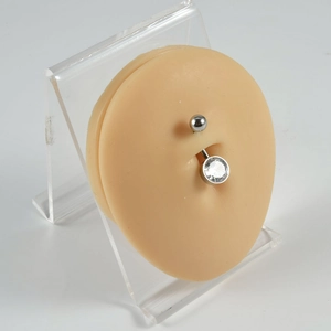 Silver stainless steel belly ring with heart-shaped white zircon on a soft silicone model