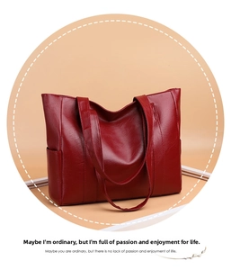 Detailed view of dark red leather tote bag with lychee texture and side pocket