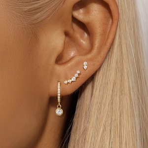 Detail shot of s925 sterling silver evil eye earring set worn on model's ear