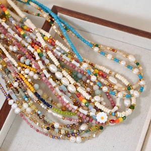 Detailed macro of colorful beaded necklace with pearls and flowers in a wooden jewelry box