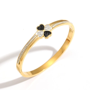 Elegant gold four-leaf clover open bangle with black and white pavé crystals decoration