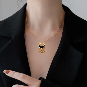 Golden titanium steel necklace with black lock pendant and three bells on model
