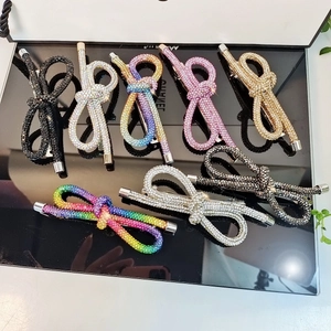 Elegant crystal bow hair clips in multiple colors on a reflective black surface