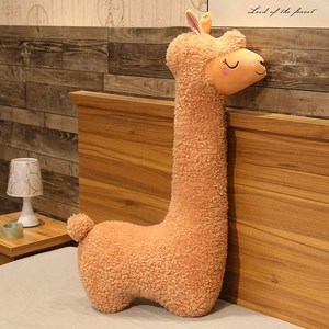 Detailed side view of a cute apricot alpaca plush toy pillow with curly faux fur