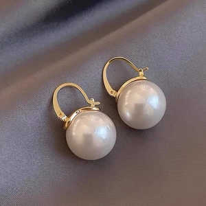 Gold-plated hoop earrings with large round pearls on premium grey silk background