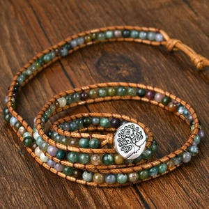 Detailed view of Indian agate beaded bracelet with Tree of Life metal button on wood