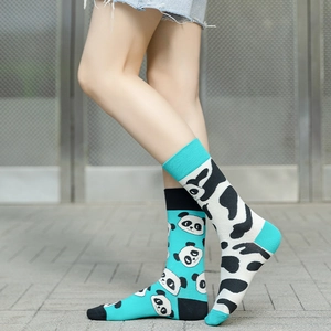 Detail shot of asymmetric cotton socks featuring panda face and cow print in blue and black