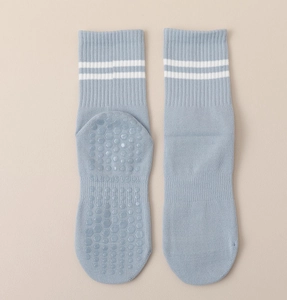 Detailed view of blue mid-calf yoga socks with white stripes and non-slip silicone grip