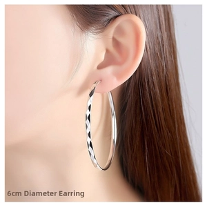 Polished silver hoop earrings with diamond-cut texture and 6cm diameter size detail