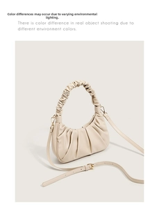 Detailed shot of beige pleated croissant bag with soft faux leather and gold hardware